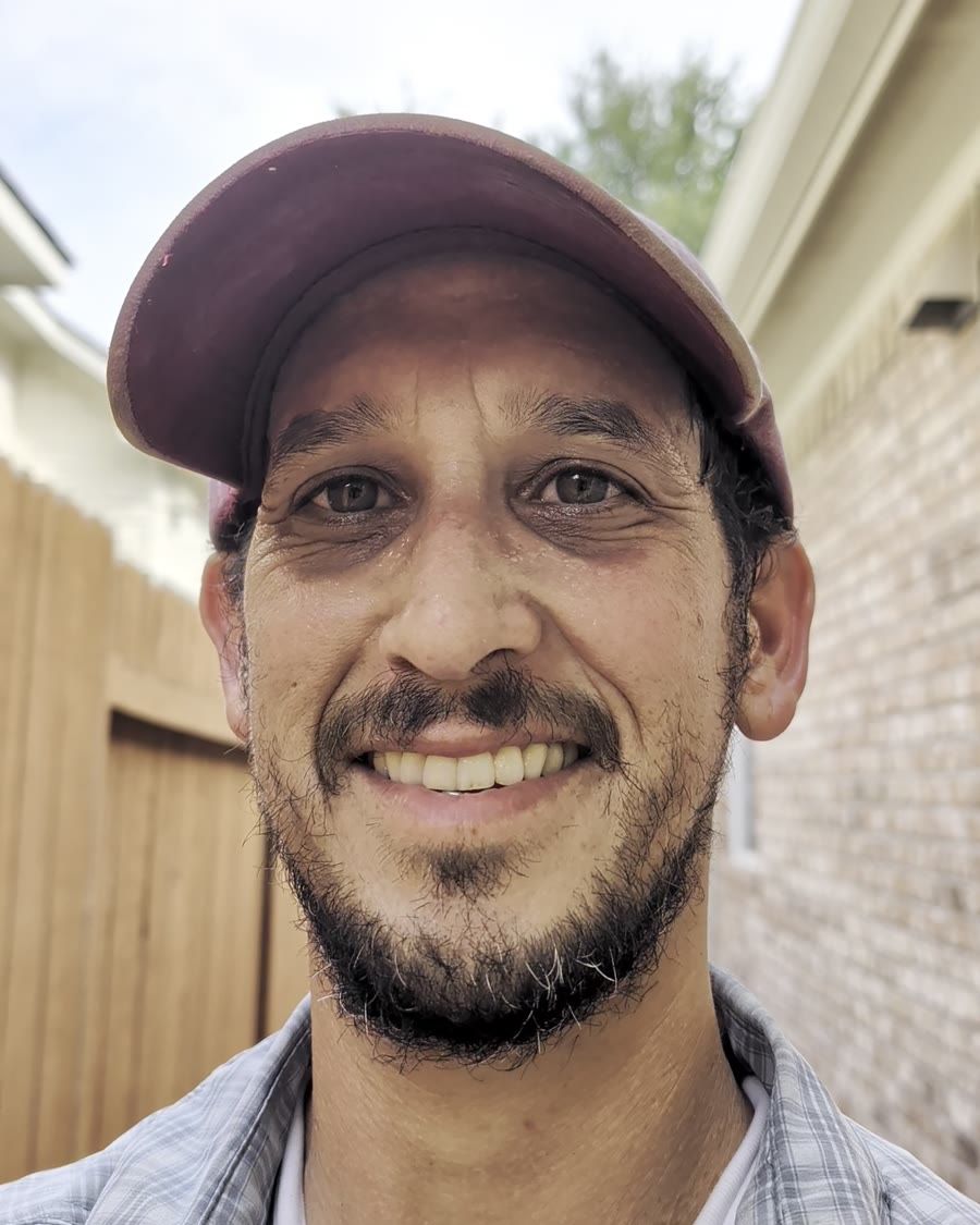 Dan Shalev, owner of DanEden LLC, smiling in a cap on a job site